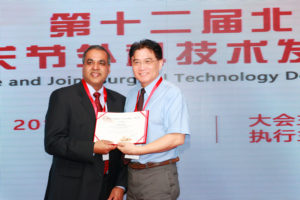 Dr. Qiu presents Dr. Gupta with certificate